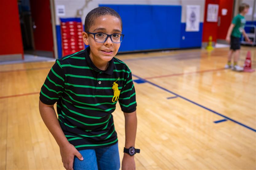 a boy wearing a green shirt smiles